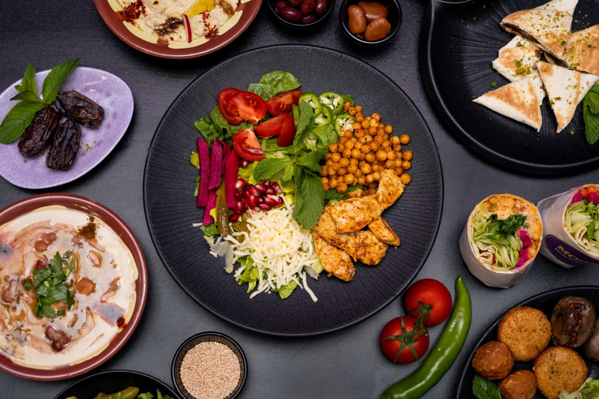 MOGO-Gerichte zum Teilen: Bowl, Hummus, Falafel, Wraps und Fladenbrot auf einem gedeckten Tisch